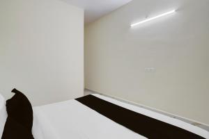 a white room with a bed and a wall at SPOT ON Hotel Royal Inn in Chandrapur