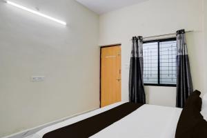 ein Schlafzimmer mit einem Bett und einem Fenster in der Unterkunft SPOT ON Hotel Royal Inn in Chandrapur