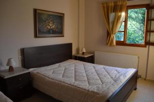 a bedroom with a large bed and a window at Dodis Village in Platanias