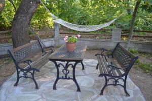 two benches and a table with a potted plant on it at Dodis Village in Platanias
