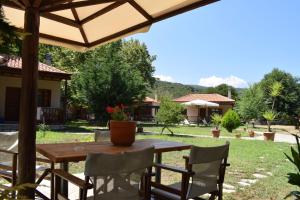 a table and chairs under an umbrella in a yard at Dodis Village in Platanias