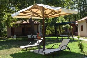 a table and chairs under an umbrella in a yard at Dodis Village in Platanias