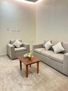 a living room with two couches and a coffee table at راوند الشرق للشقق المخدومة in Hafr Al Baten +1 photo