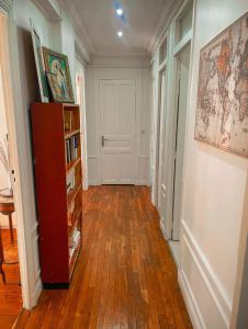 a hallway with a wooden floor and a book shelf at Tour Eiffel - Grand appartement 2 chambres 110m2 in Paris