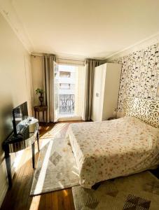 a bedroom with a bed and a desk and a window at Tour Eiffel - Grand appartement 2 chambres 110m2 in Paris