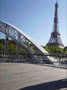 a bridge with the eiffel tower in the background at Tour Eiffel - Grand appartement 2 chambres 110m2 in Paris