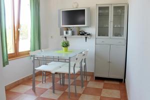 a dining room table with chairs and a tv at Apartments Villa Milna 1 in Budva