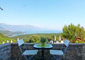 a table and chairs on a stone wall with a view at Apartments Villa Milna 1 in Budva