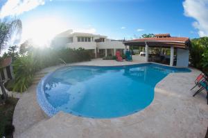 a large swimming pool in front of a house at Bella Noni B&B in Aguadilla