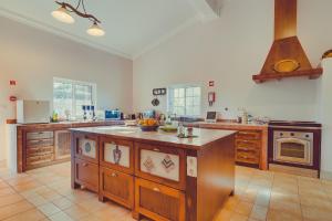 a large kitchen with an island in the middle at Espargosa Monte de Baixo & Art in Castro Marim