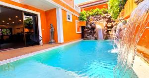 a swimming pool with a waterfall in a house at WOWLAND Luxury Pool Villa Pattaya Walking Street 6 Bedrooms in Pattaya South