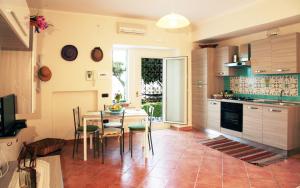 uma cozinha com mesa e cadeiras num quarto em Vacation Home Agrumeto Flegreo em Nápoles