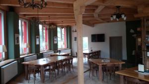 una sala da pranzo con tavoli e sedie in legno di Hotel BouCZECH a Lipno nad Vltavou