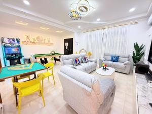 a living room with couches and a ping pong table at UjongPasir18paxLanded10minstoJonker in Melaka