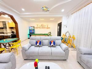 a living room with a couch and a pool table at UjongPasir18paxLanded10minstoJonker in Melaka