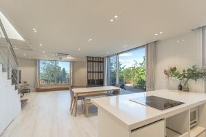 eine große Küche mit Tisch und Esszimmer in der Unterkunft Aewol Damdam Stay in Sowang-dong + 32 Fotos