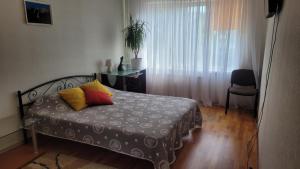a bedroom with a bed with two pillows on it at Затишна квартира в центрі Оболоні м Київ in Kyiv