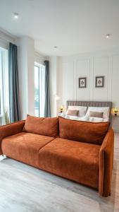 a large orange couch in a room with a bed at Wohnbude Hauptbahnhof in Vienna