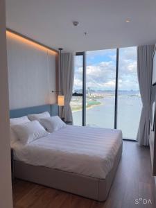 a bedroom with a bed with a view of the ocean at Alacarte Hạ Long Bích Ngọc in Ha Long