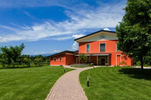a house with a grassy yard next to a path at Agriturismo la Chiocciola in Sacile