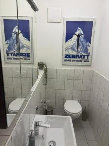 a bathroom with a toilet and a sink with two posters at Wohnung am Auepark in Kassel +9 photos
