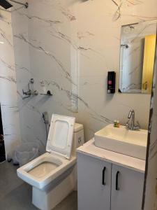 une salle de bain avec des toilettes blanches et un lavabo dans l'établissement The Happy Land Mussoorie, à Mussoorie