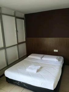a bedroom with a bed with two towels on it at medan inn in Bintulu