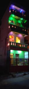 a building with green and purple lights on it at Night Stay Guest House 8PM to 8AM Non AC and No Car Parking Near Kamatchi Amman Temple in Kanchipuram