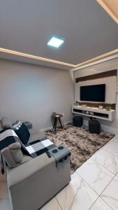 a living room with a couch and a flat screen tv at Casa á 400m da Praia de Cabo Branco in João Pessoa +50 photos