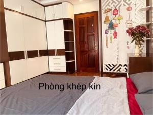 a bedroom with a bed and a wooden door at Laca Home in Hanoi +3 photos