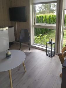 a living room with a table and a large window at Stylish Cabin Experience In Beautiful Surroundings in Færvik