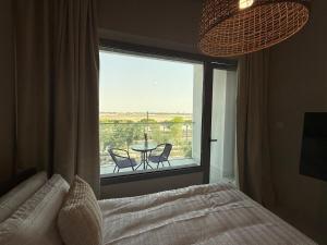 a bedroom with a bed and a window with a table and chairs at The chic Retreat Stylish Studio 2 in Abu Dhabi +10 photos