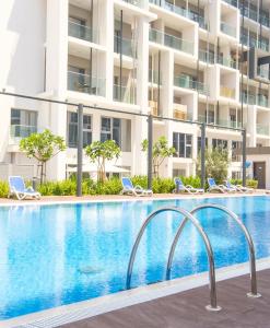 a swimming pool in front of a building at The chic Retreat Stylish Studio 2 in Abu Dhabi