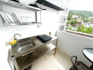 una cucina con un lavandino e una finestra di Patong Canal Villa 302 a Patong Beach Altre 19 foto