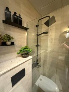 a bathroom with a shower with a toilet in it at The chic Retreat Stylish Studio 2 in Abu Dhabi