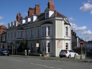 un coche blanco estacionado frente a una casa blanca en Christleton House en Llandudno