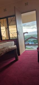 a bedroom with a bed and a window with a red carpet at Eagle Nest lake Natron Guest House in Mtowabaga