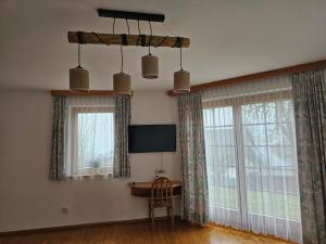 Habitación con ventanas, escritorio y TV. en Apartment Ad Alta Matschiedl 2, en Matschiedl