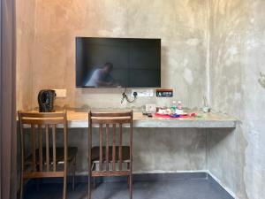 クアンタンにあるLE LODGE MANSIONの壁にテレビと椅子2脚が備わるバー