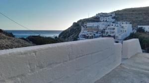 a white building on a hill next to the ocean at Perigiali Rooms & Apartments Folegandros in Agali