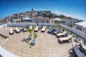a patio with lounge chairs and tables on a roof at Relais La Pretura in Vieste