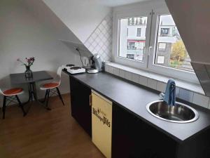 a kitchen with a sink and a table and a window at Bei Pina - Schöne Dachgeschosswohnung nahe Düsseldorf in Solingen