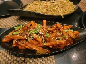 a plate of food on a table with pasta at Hotel OPM in Agra