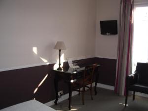a room with a desk with a lamp and a chair at Villa Saint Hubert in Nice