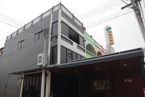 a gray building with a balcony on top of it at Peema Villa ภีมะ วิลล่า in U Thong