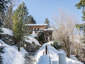 a house covered in snow with stairs in front at Chalet with Views, Privacy & Fire in Kaprun in Kaprun