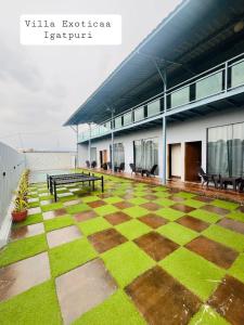 a patio with benches and grass on a building at Villa Exotica, Igatpuri in Ghoti Budrukh