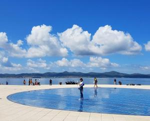 a man standing next to a swimming pool on a beach at Apartment Marija in Novigrad Dalmatia