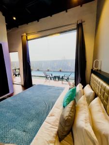 a large bed in a room with a large window at Villa Exotica, Igatpuri in Ghoti Budrukh