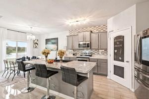 une cuisine avec une grande île et des chaises noires dans l'établissement Lakefront Luxury Retreat 5BR, à Jacksonville